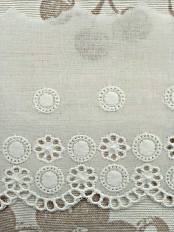 Puntilla bordada ojetes rodeados